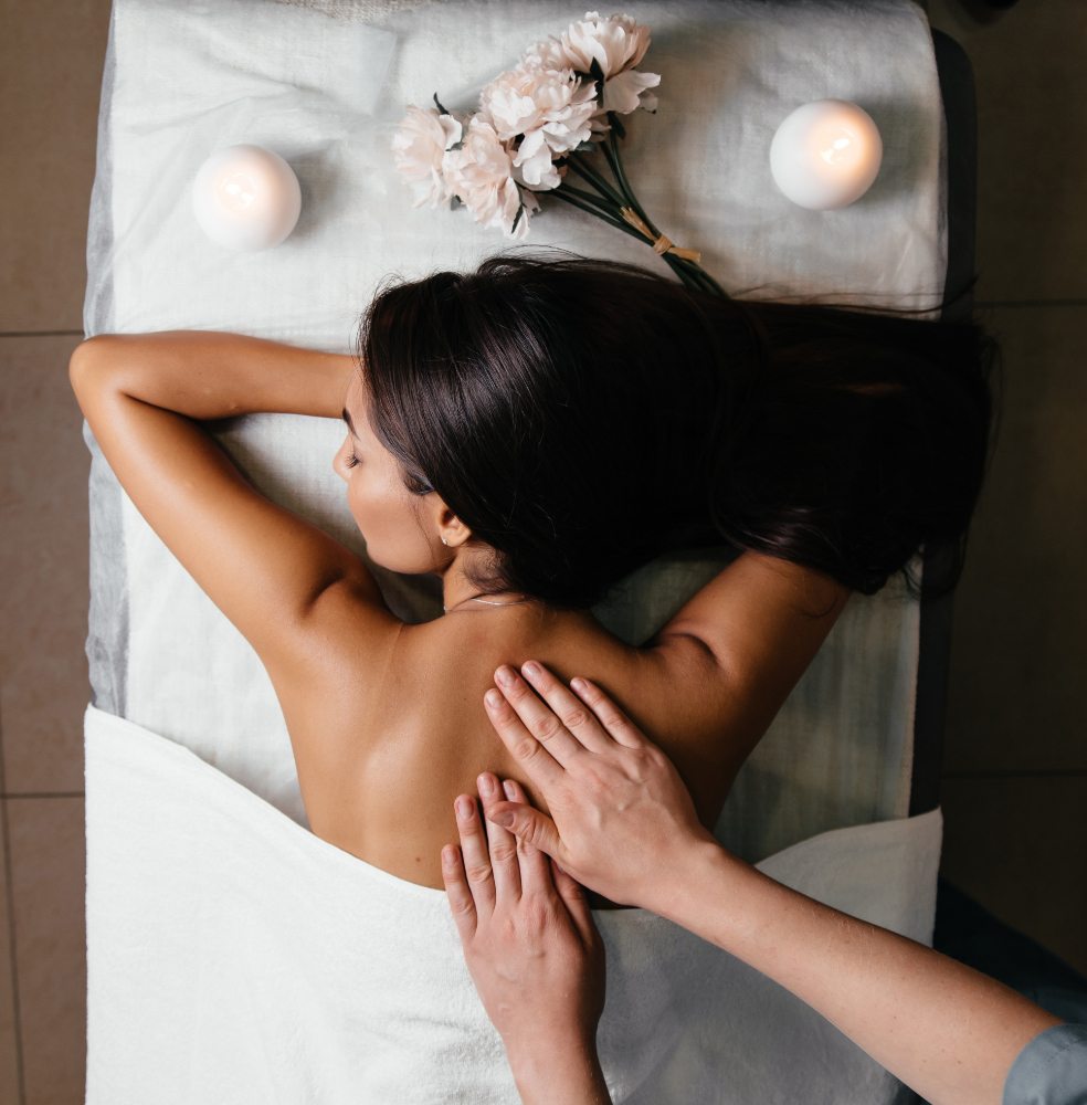 Client receiving a back massage in a candlelit treatment room