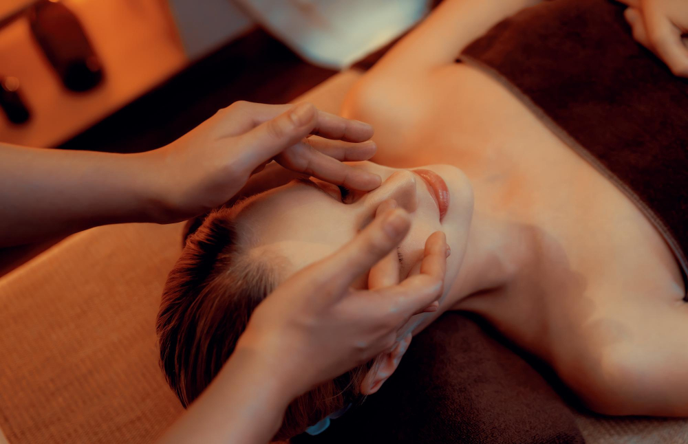 Therapist massaging a client's face and neck
